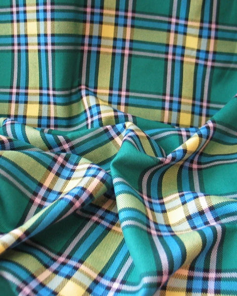 Close-up of plaid fabric with green, yellow, and blue colors.