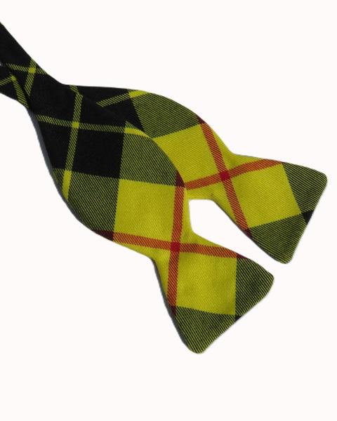 Plaid bow tie with bright yellow, black, and red plaid pattern on a white background