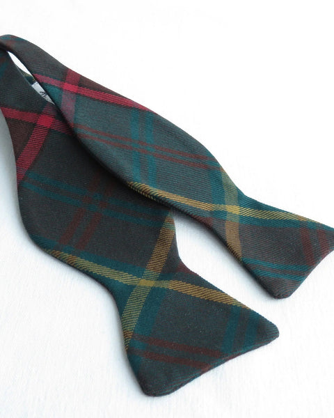 Plaid bow tie with red, green, and yellow colors on a white background
