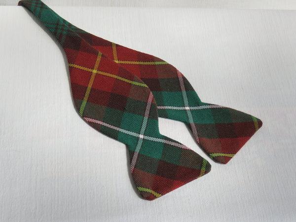 Rust and green plaid freestyle bow tie laying flat on a white background.