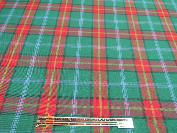 Green plaid fabric with red and yellow lines, shown with a ruler to indicate the size of the pattern.