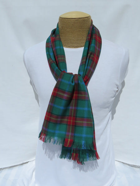 Green plaid Manitoba tartan scarf on a mannequin dressed in a white top, displayed against a white background.