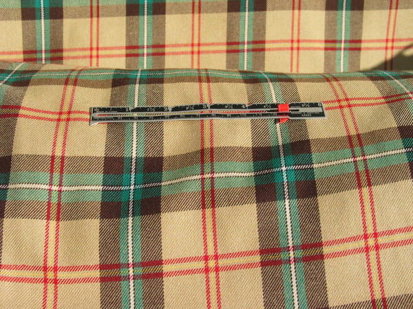 Yellow plaid Saskatchewan tartan fabric with a ruler placed to show the scale of the tartan pattern.
